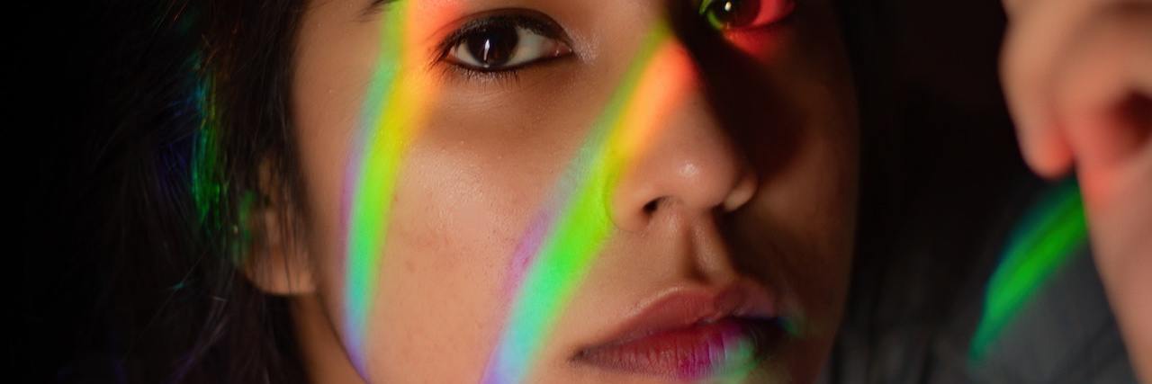 A woman with rainbow streaks across her face