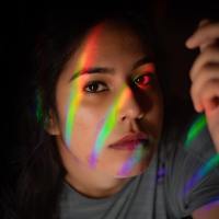 A woman with rainbow streaks across her face