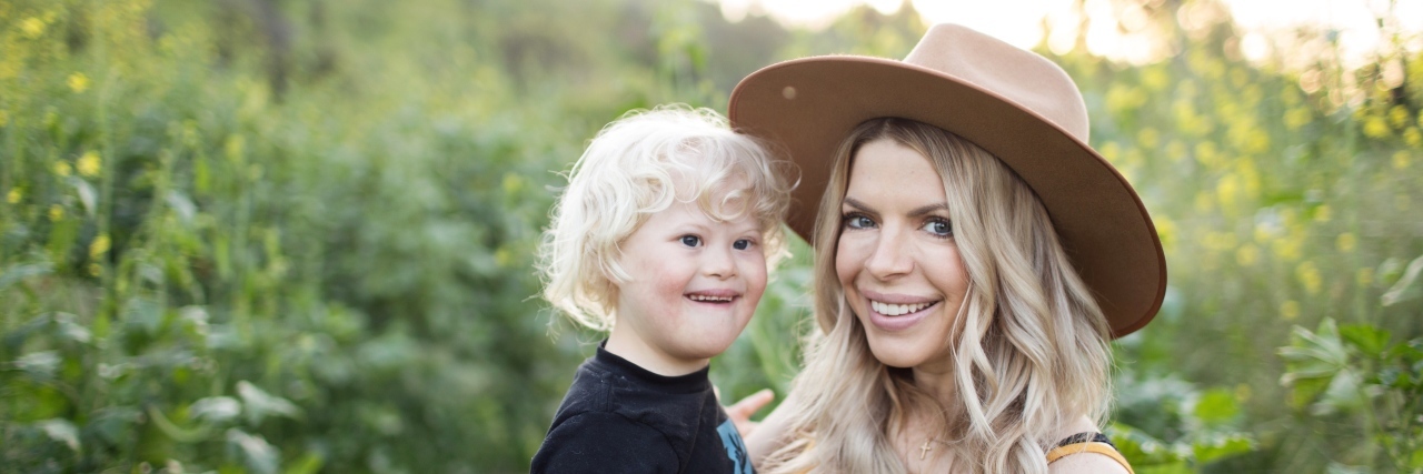 Adults With Down Syndrome Are Not 'Forever Babies' Michelle in the jungle holding her son who has Down syndrome.