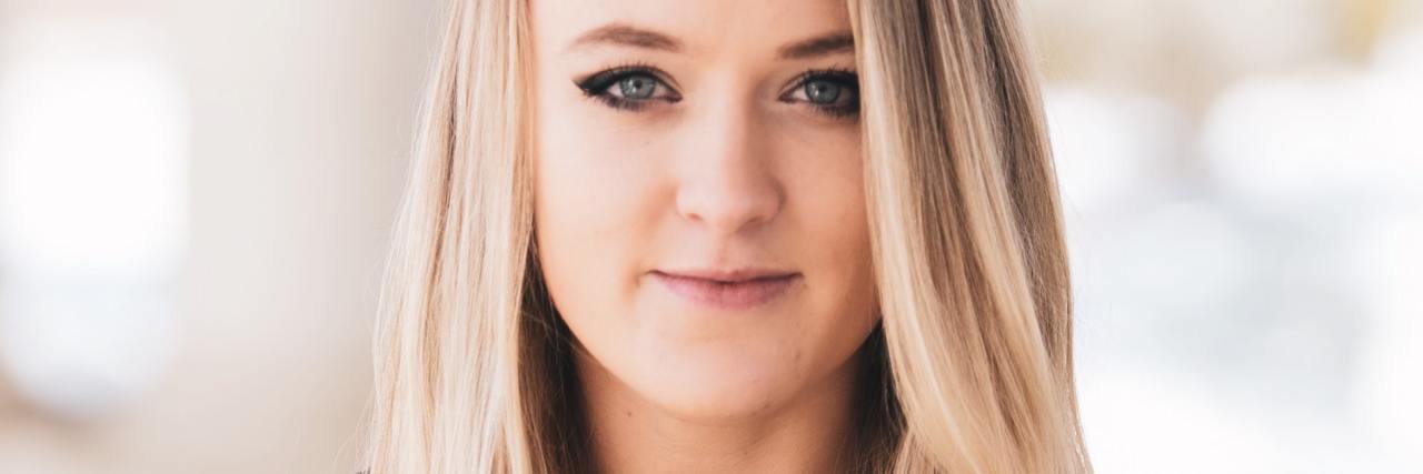 My Experience With Vulnerability and Mental Health in the Workplace photo of blonde woman looking into camera with slight smile