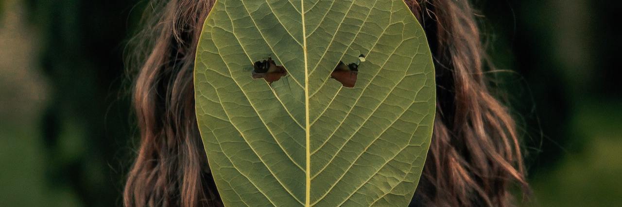 One Positive of Having an Invisible Chronic Illness A woman holding a leaf over her head