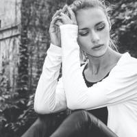 black and white photo of woman looking tired while sitting outside