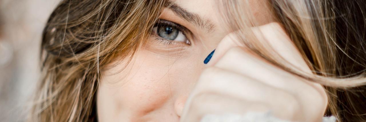 How to Take a Compliment in Eating Disorder Recovery photo of woman looking into camera, covering face and smiling, looking shy
