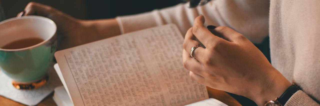 Self-Care Ideas for After Hard Therapy Sessions photo of woman's hands with coffee cup and an open book in golden light