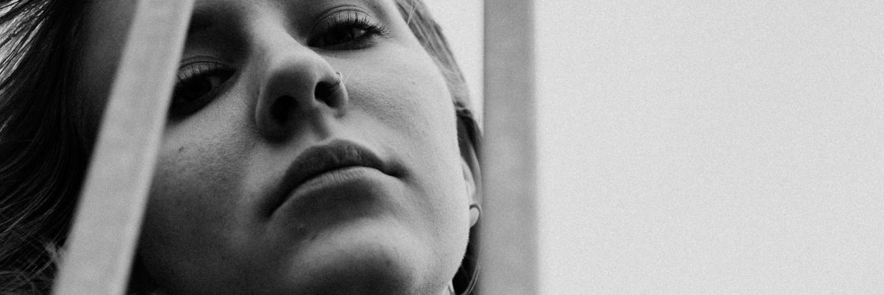 Depression Makes You Feel Like a Prisoner in Your Own Mind black and white photo of young woman behind vertical bars
