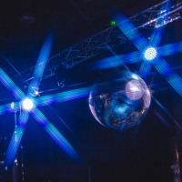 Blue background disco ball with disco lights.