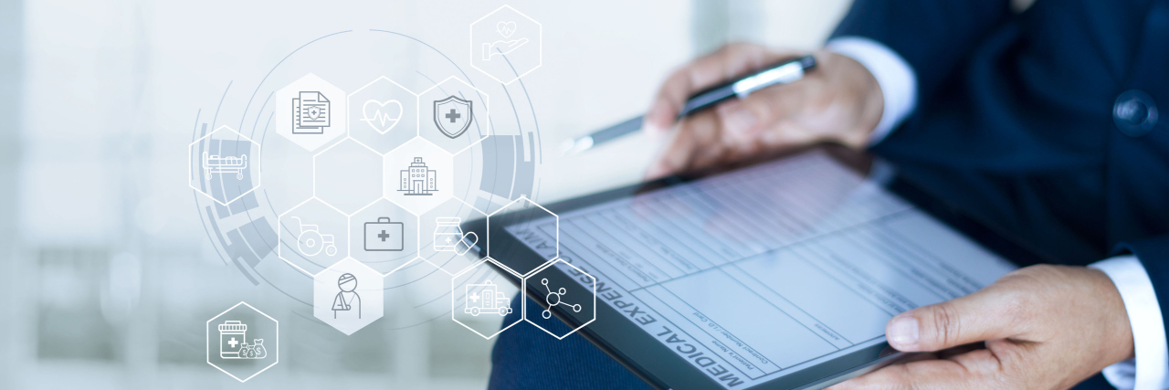 Think Your Health Care Is Covered? Beware of the ‘Junk’ Insurance Plan Businessman completing a medical claim form with insurance icon health care on tablet digital.