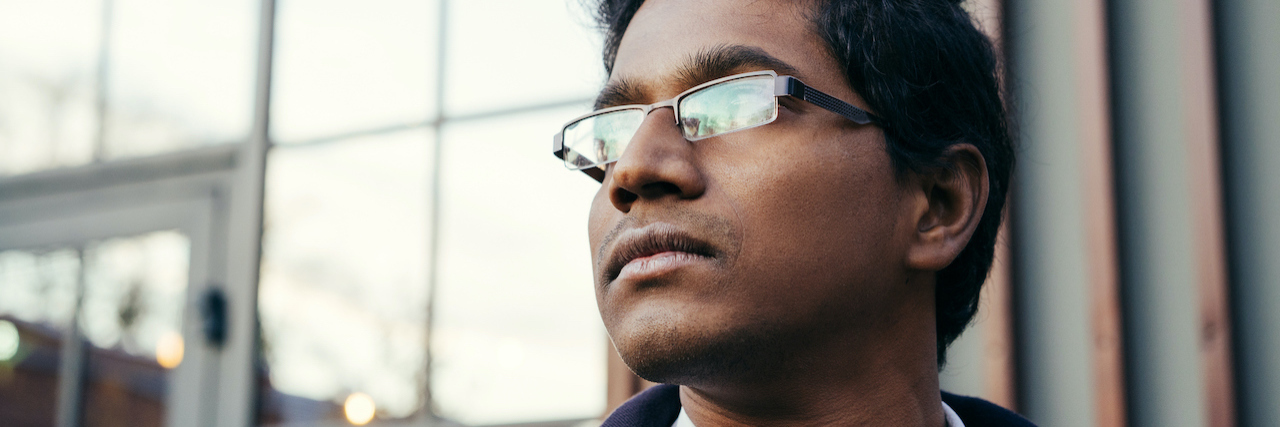 Supporting My Brother Who Has Bipolar Disorder A man standing outside an office wearing glasses