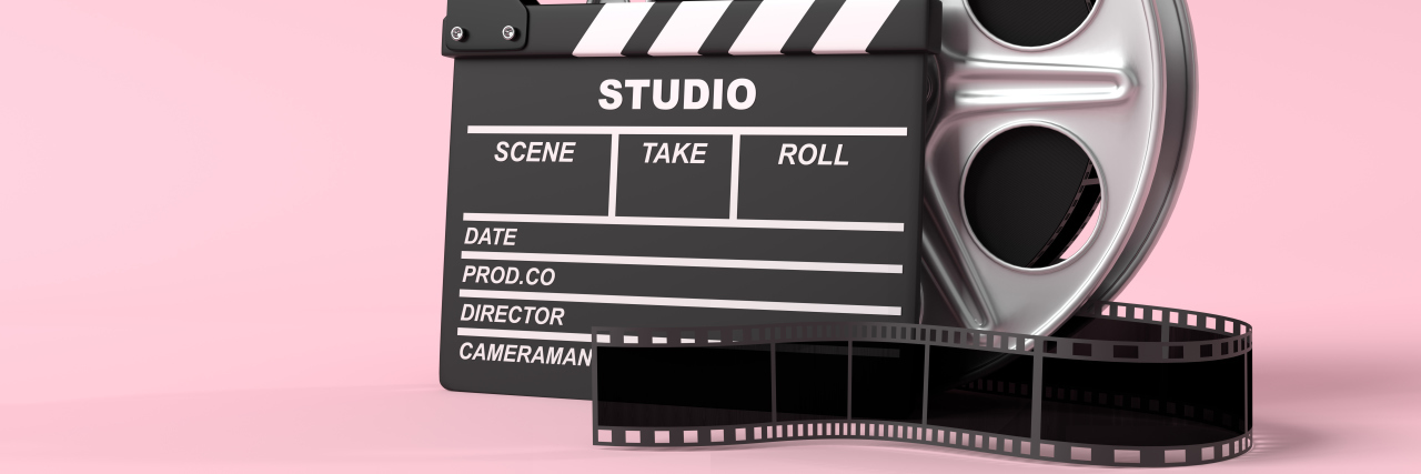 Film reel with clapperboard on bright pink background.