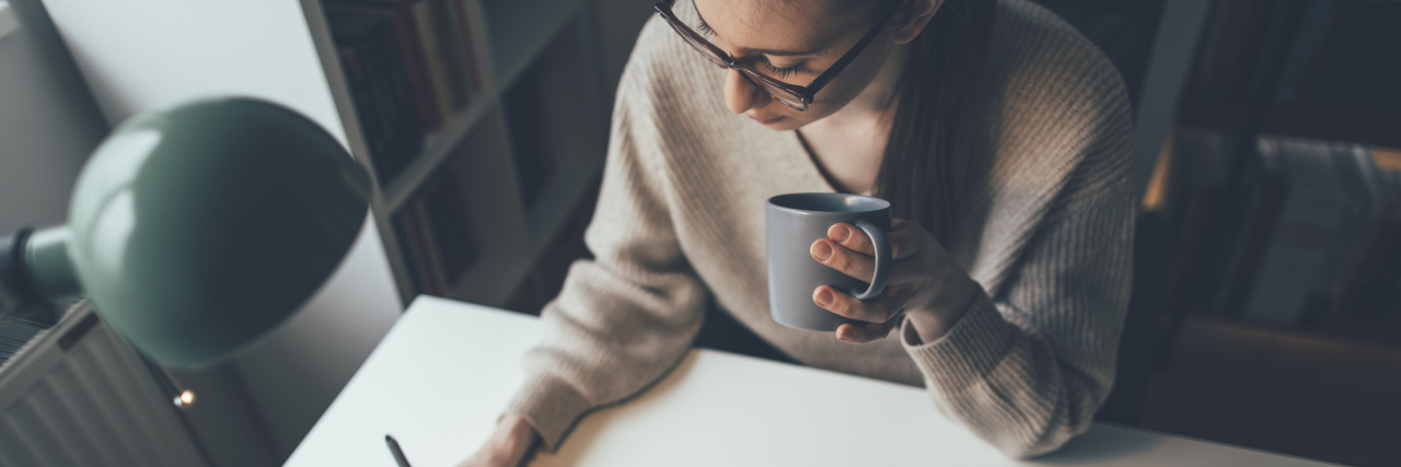 Workplace Accommodations for Bipolar Disorder a woman working from her home on a laptop drinking coffee