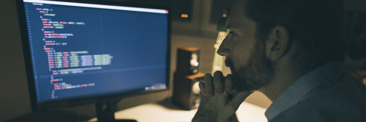 When Being Autistic Means I Can't Stop Paying Attention Bearded man focused on reading computer codes.