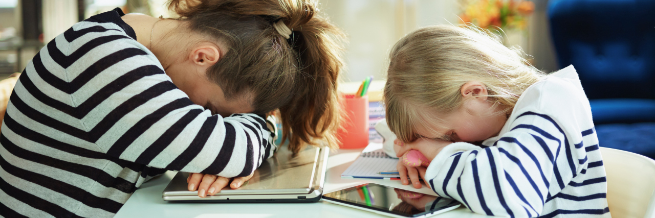 COVID-19: We Need Better Mental Health Services for Parents tired young mother and child in striped sweaters in home office in the modern living room in sunny day laying on table.
