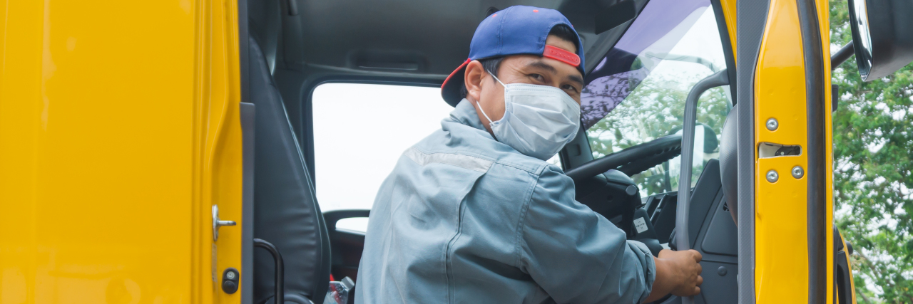 Mental Health Crisis Among Essential Workers A driver wearing a mask stepping into his truck