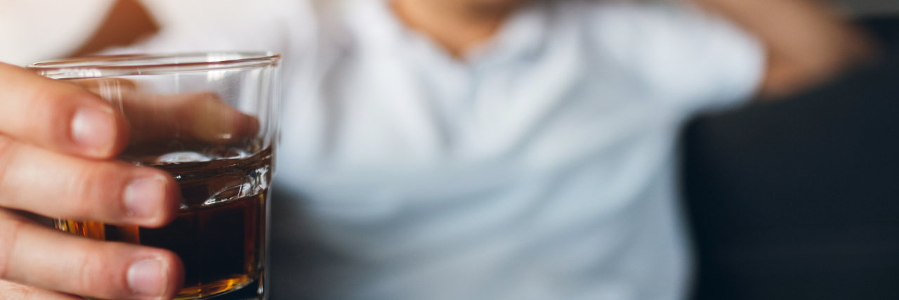 An Alcoholic's Perspective on Drinking During the Pandemic A man holding a glass of whiskey