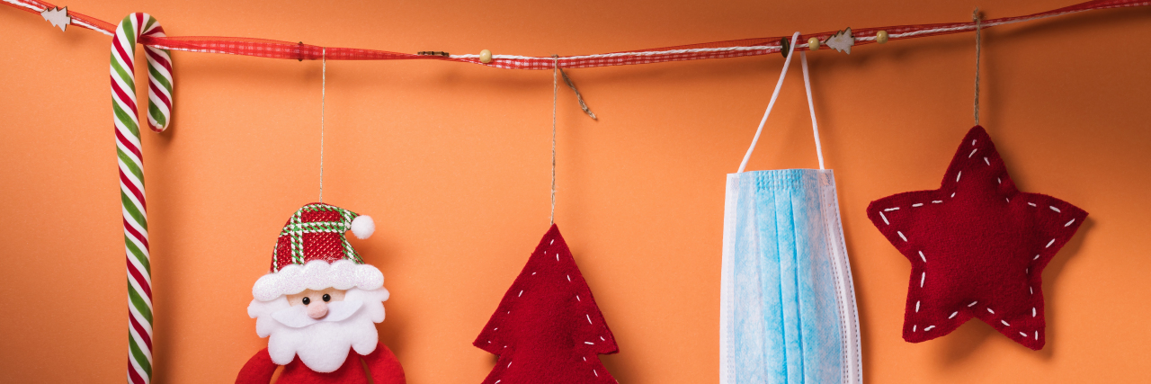 Why COVID-19 Is a Good Excuse to Not See Toxic Family For the Holidays Christmas decorations next to a mask