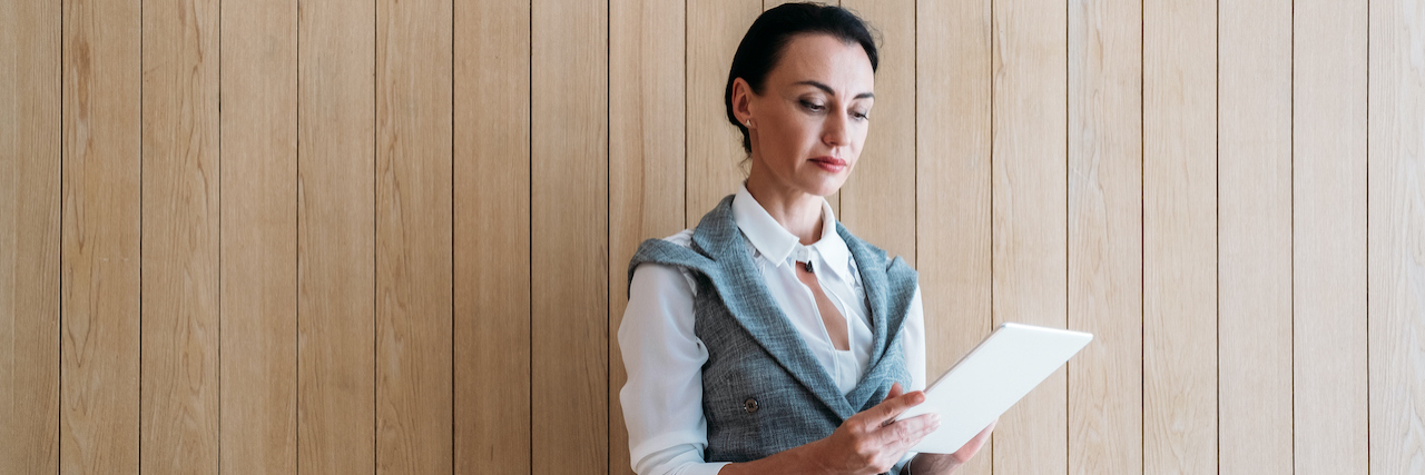 I'm a Female Executive With an Eating Disorder A woman holding a piece of paper and looking serious