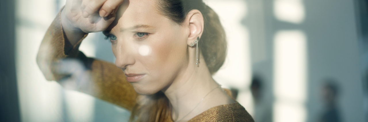 Feeling Stigmatized by Other Suicide Loss Survivors A woman looking out the window