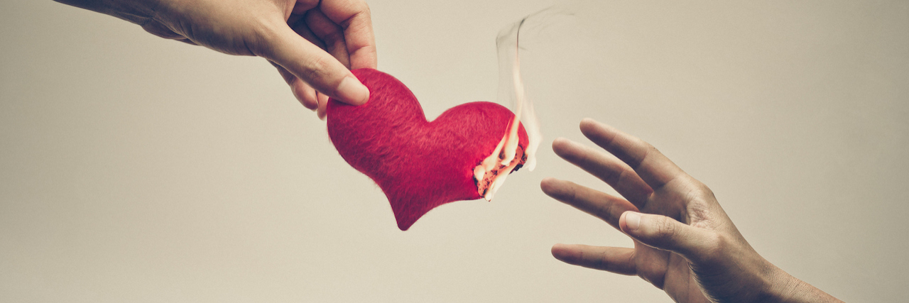Female hand giving a heart on fire to male hand