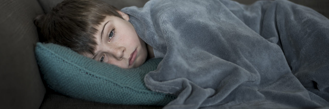 When My Son With HIE Had His First Seizure Boy sick or sleepy on the sofa.