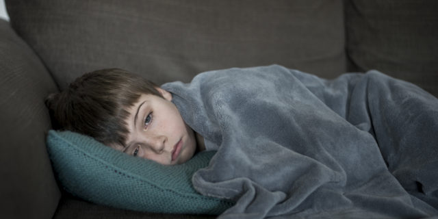 Boy sick or sleepy on the sofa.