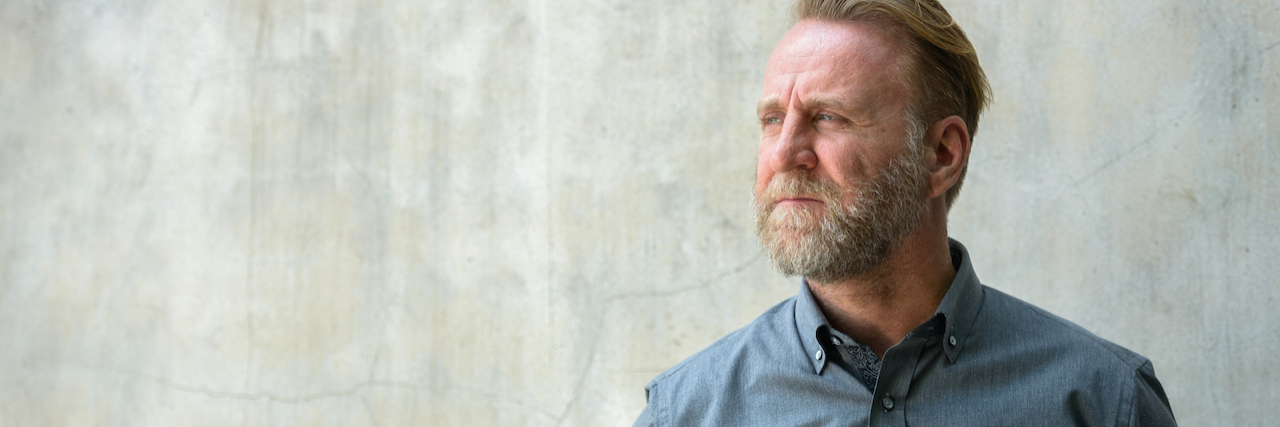 Getting Diagnosed With Nonverbal Learning Disability as an Adult A man with a beard standing against a wall