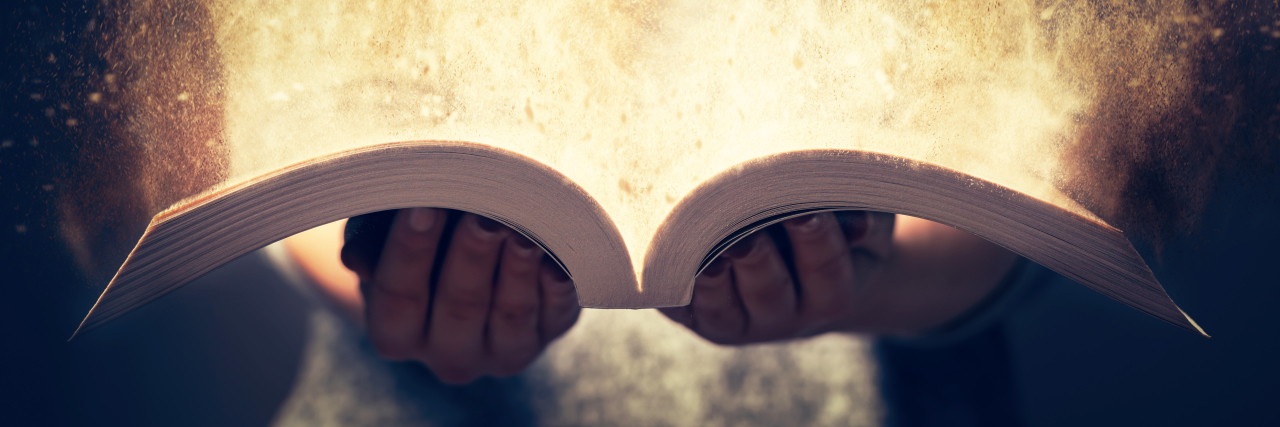 The Day I Learned I Was Twice Exceptional a woman holding open a book with light coming out of it