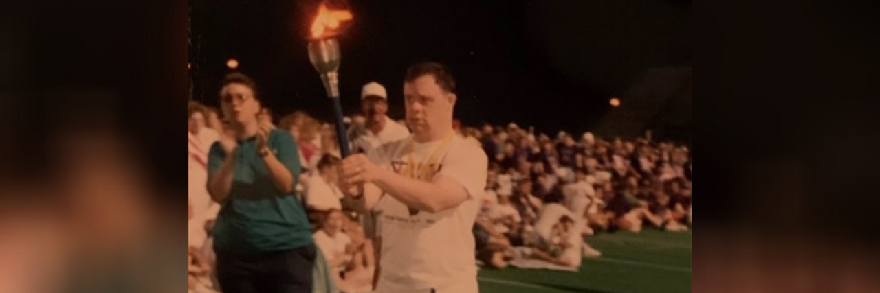 Michael Cusack carrying a torch at a special olympics event