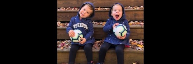 twin toddler girls sitting on steps laughing with balls