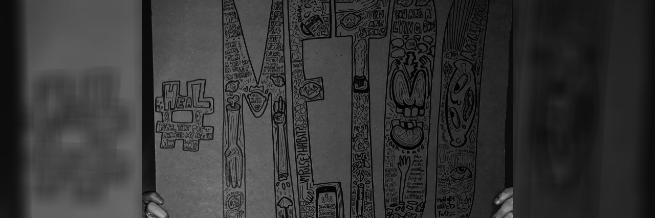 On Being Raped When Believing Survivors Was Fashionable photo of a woman's hands holding a sign which reads "#metoo" with other related words inside the letters