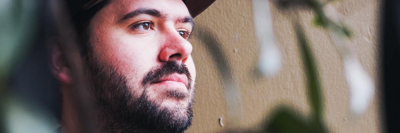 My First Experience With Botox for Migraines A man with dark hair and a beard wears a ball cap and looks off into the distance