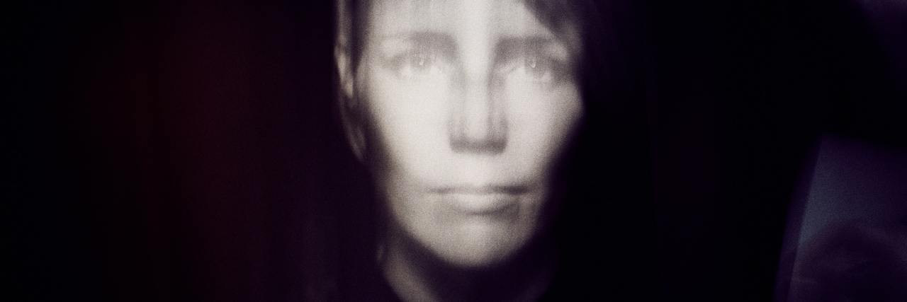 Read This if COVID-19 and Everything Else Feels Too Much Right Now black and white photo of woman looking into camera with a disorted face