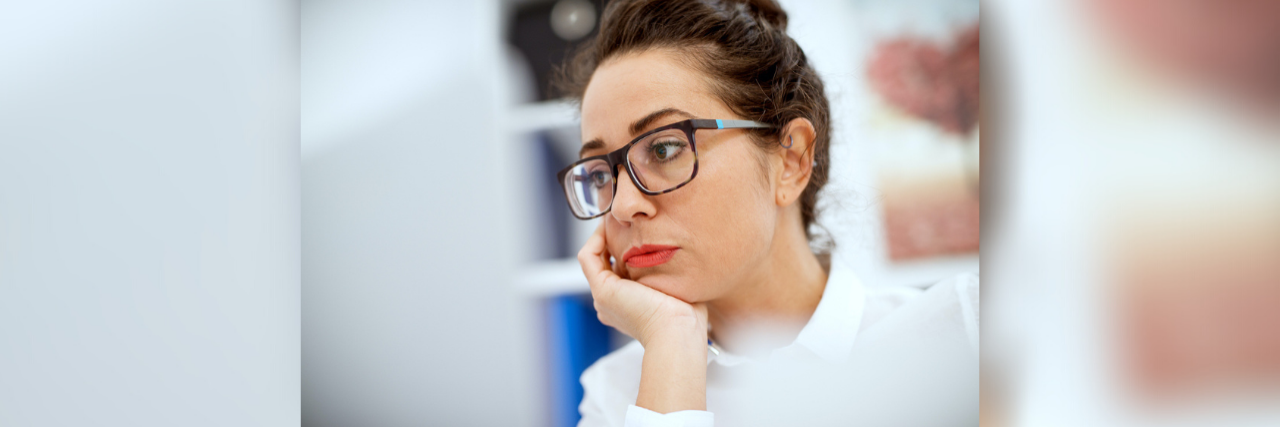 Woman wearing glasses and looking at computer screen