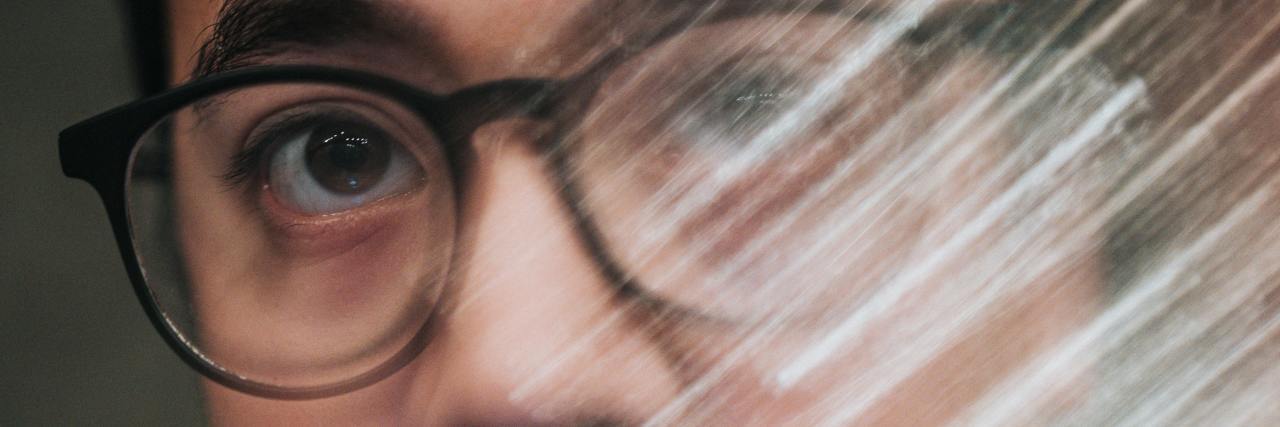When Mental Illness Symptoms Are Too Much for Friends A man with glasses with white blurs in front of his eyes