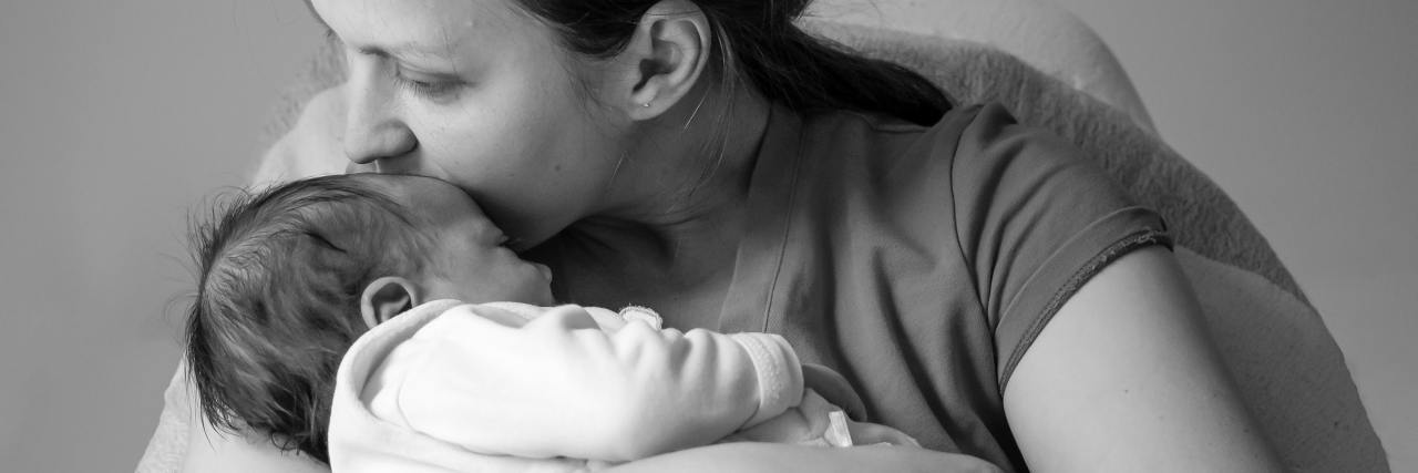 My Experience With Postpartum Rage and Depression black and white photo of a mother kissing her baby