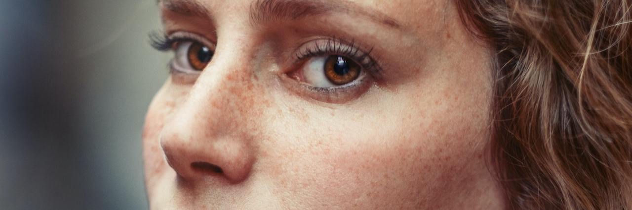 10 Hidden Red Flags of My Childhood Sexual Abuse A woman looking over her sholder