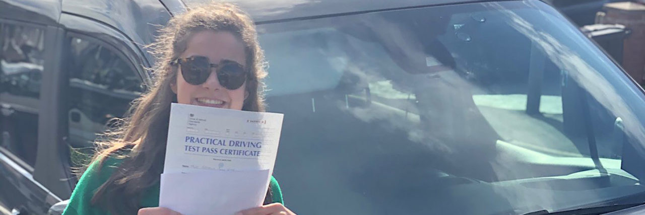 The Long Road to Passing My Driving Test With Cerebral Palsy Georgia holding her driving test certificate.