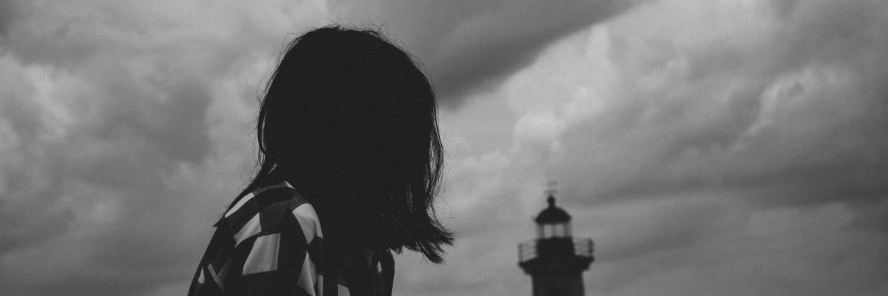 Woman looking at a lighthouse.