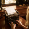 Woman using vintage typewriter.