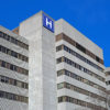 Large concrete building with H sign for hospital