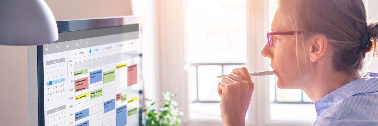 Woman looking at calendar on computer screen.