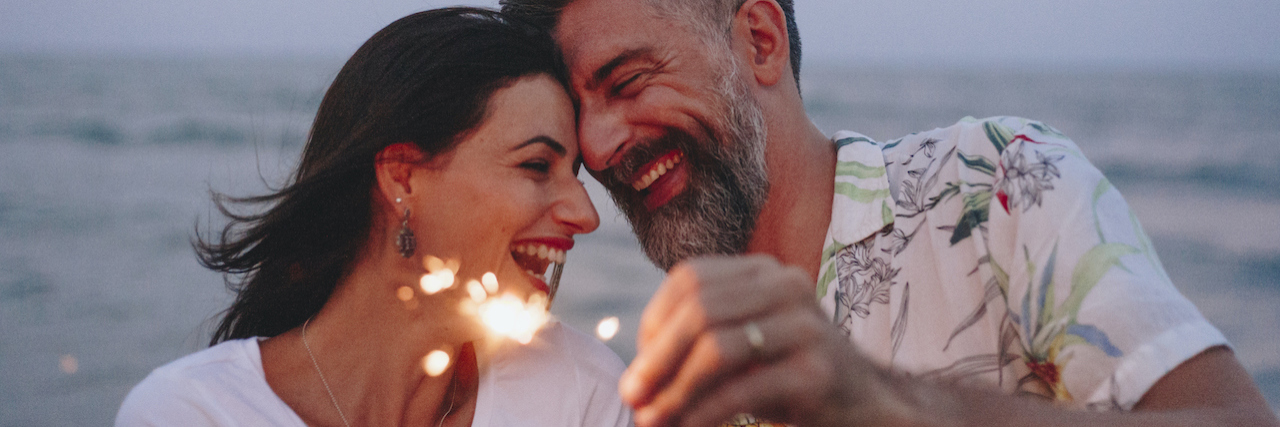 How to Have a Great Relationship While Living With Bipolar Disorder Couple celebrating with sparklers at the beach