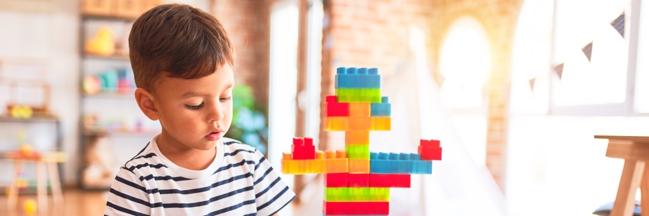 Why Choosing Therapy Instead of Remote Learning Helped My Autistic Son Boy playing with construction blocks.