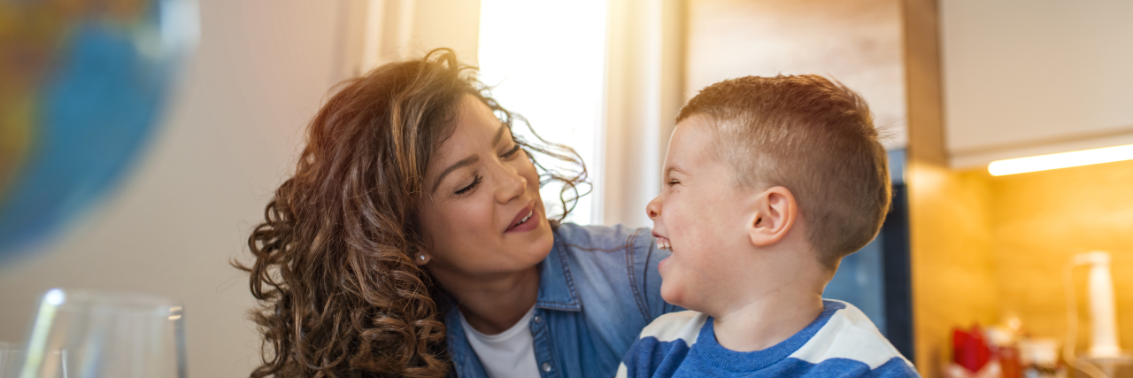 A Letter to My Child on the Autism Spectrum Mother helping her son doing homework in kitchen.