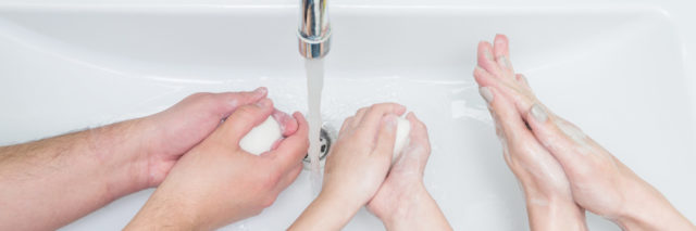 Family washing hands with soap.