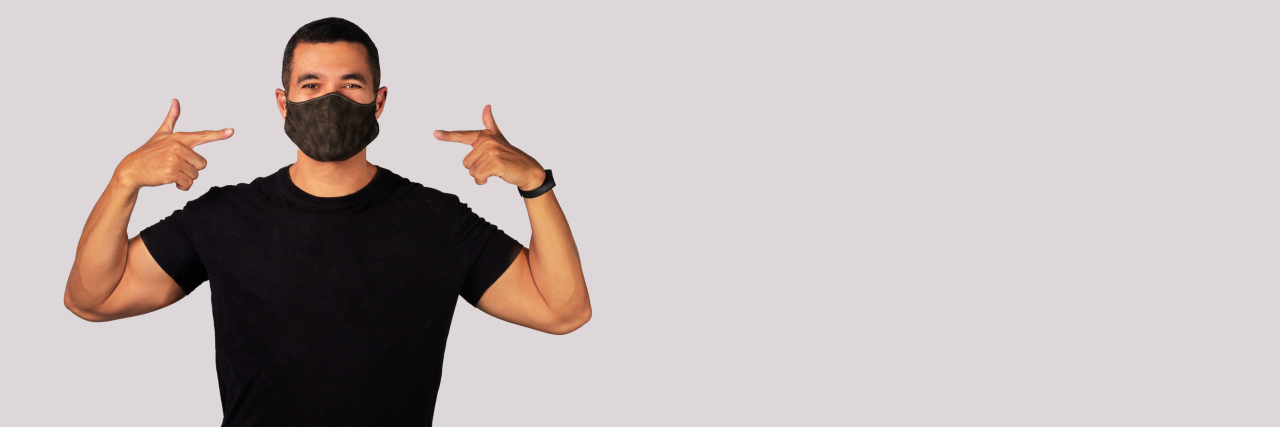 5 Reasons to Wear a Mask Even After You’re Vaccinated for COVID-19 An adult man with black shirt with a N95 face mask to protect himself against the coronavirus