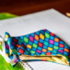 Colorful face mask lying on top of a linked paper notebook