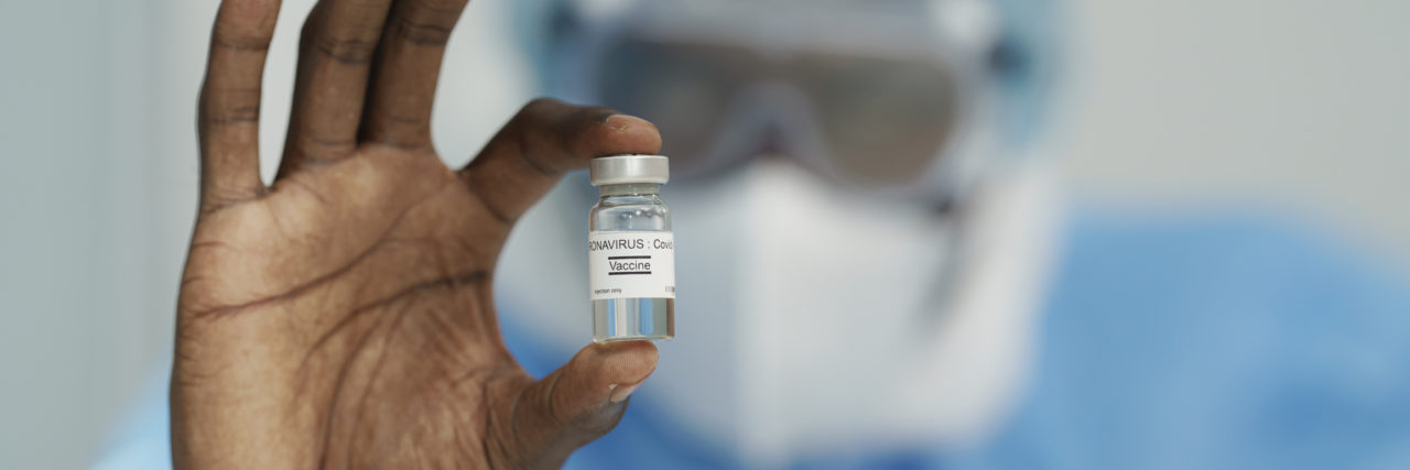 10 Ways to Track Everything About the COVID-19 Vaccines closeup of coronavirus covid-19 vaccine in bottle in hand of Black doctor