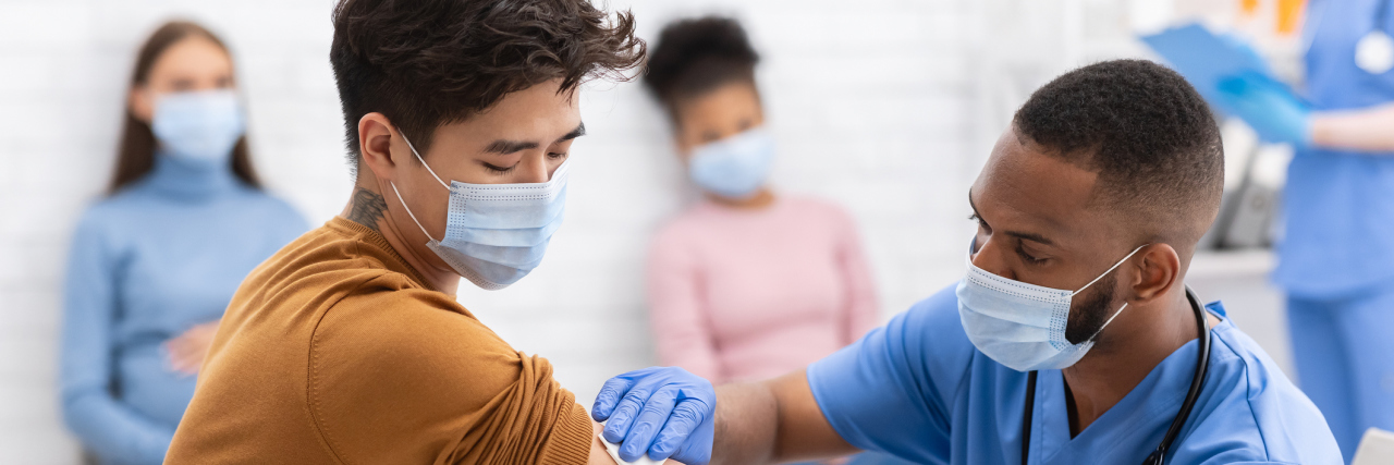 Poll: Nearly Half of American Adults Now Want the COVID-19 Vaccine Man Receiving Coronavirus Vaccine Intramuscular Injection In Arm During Doctor's Appointment In Hospital.