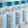 Coronavirus vaccine flasks on white background