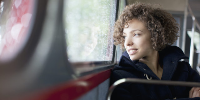 Smiling woman riding public transportation